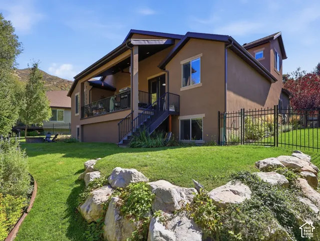 Multi-story stucco exterior with covered balcony featuring metal railings