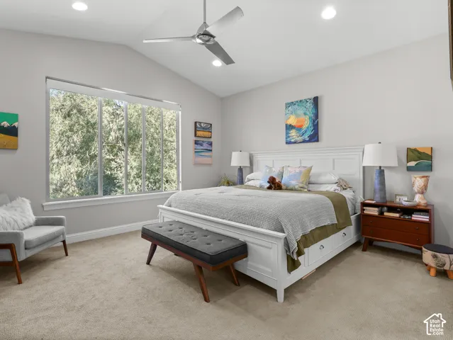 Vaulted ceiling with a ceiling fan, recessed lighting, and a large picture window