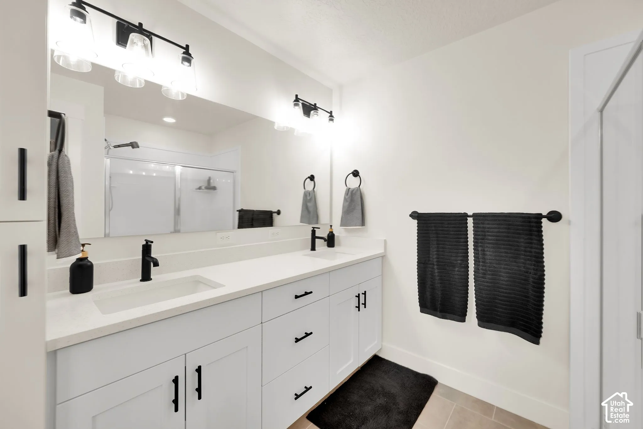 Dual vanity with white cabinetry, matte black fixtures, and a spacious countertop