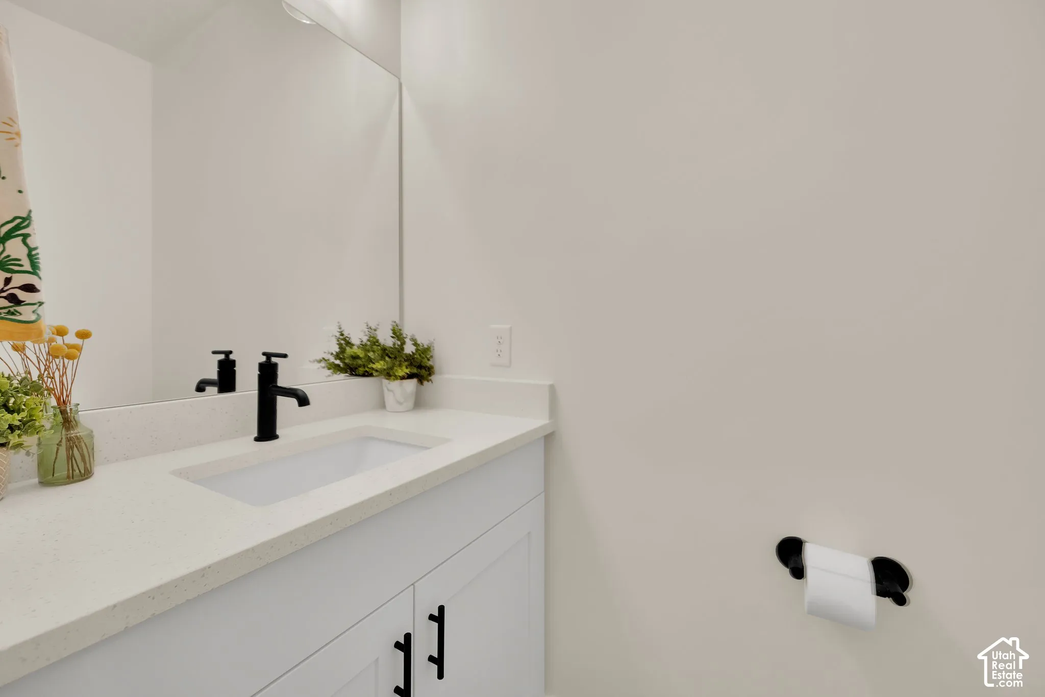 White vanity with black hardware, integrated rectangular sink, and matte black faucet