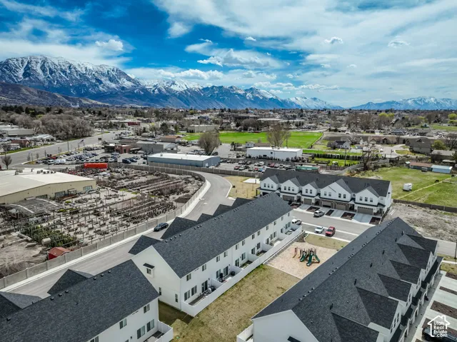 Modern townhome community featuring multiple buildings, dark shingle roofs, and light-colored siding