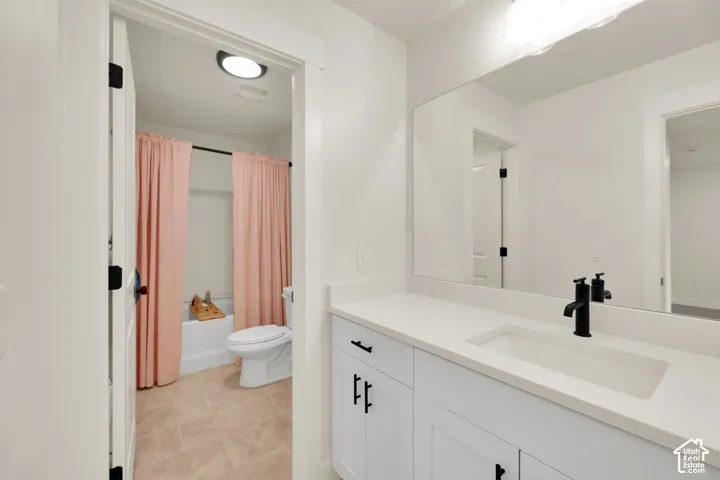 Vanity with a solid surface countertop, integrated rectangular sink, and matte black faucet