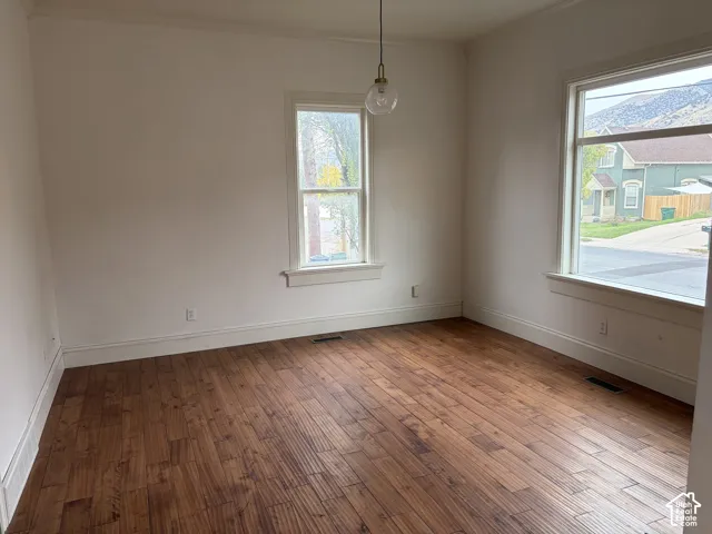 Wood-finish flooring, white trim, recessed light fixture, and multiple windows