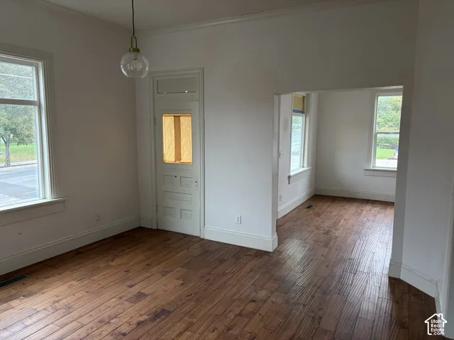 Wood-finish flooring, white trim, recessed entry, and multiple windows