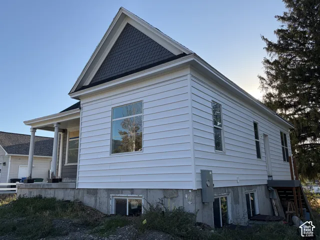 White horizontal siding exterior with a dark shingle-clad gable accent