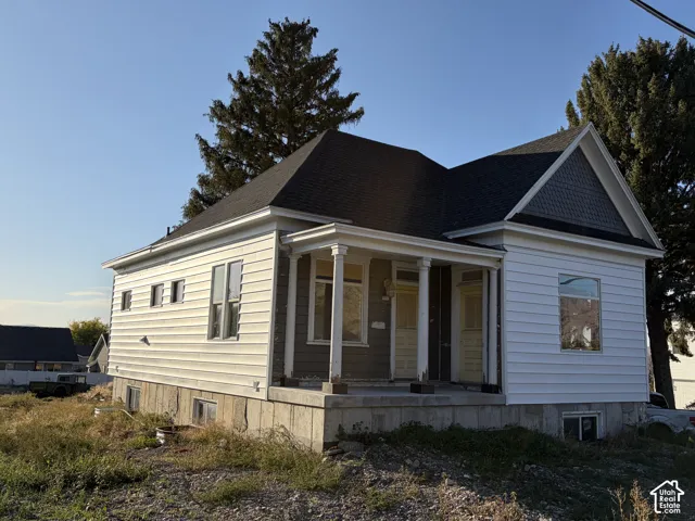 Fiber cement siding, dark shingle roof, gabled dormer, columned porch, and a concrete foundation