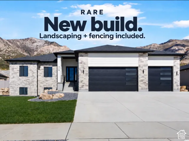 Exterior facade featuring stone veneer, horizontal siding, three-car garage with modern horizontal glazing, and a concrete driveway set against a mountain backdrop