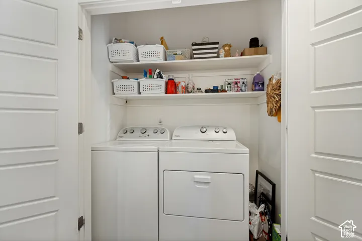 Dedicated laundry closet with built-in shelving, a washer, and a dryer