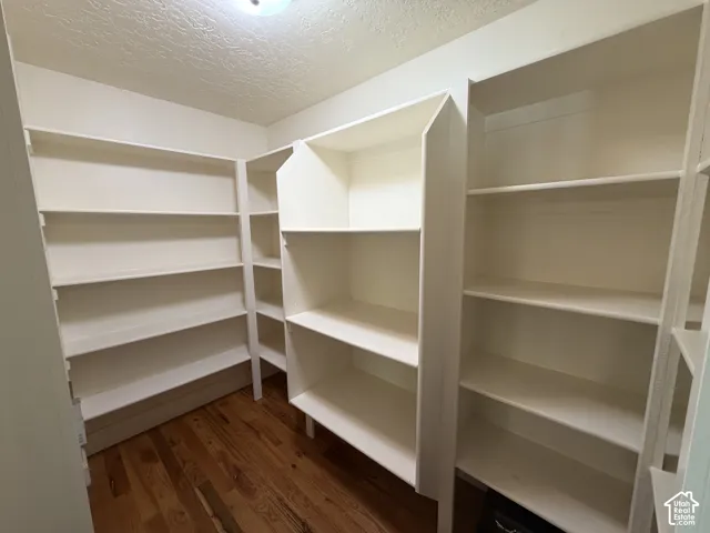 Built-in shelving providing extensive storage, wood-finish flooring, and overhead lighting