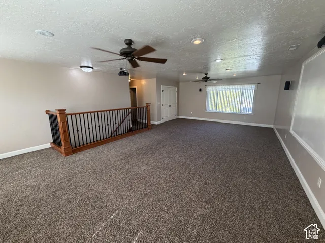 Expansive carpeted area with recessed lighting and multiple ceiling fans