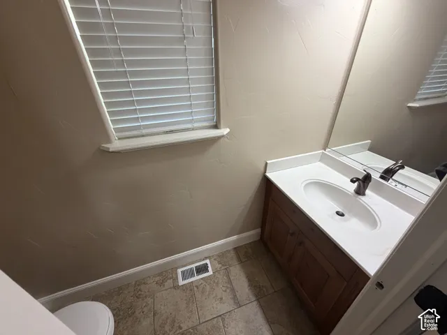 Wood-finish vanity with white countertop and integrated sink