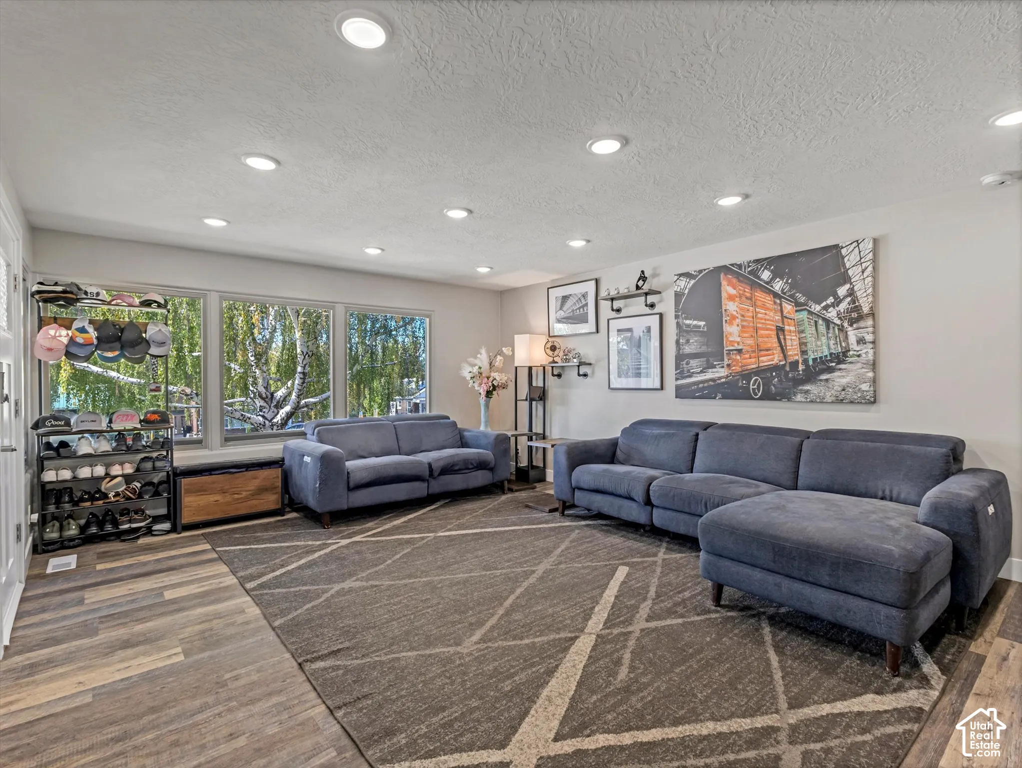 Recessed ceiling lighting, wood-finish flooring, ample natural light, and a built-in window bench