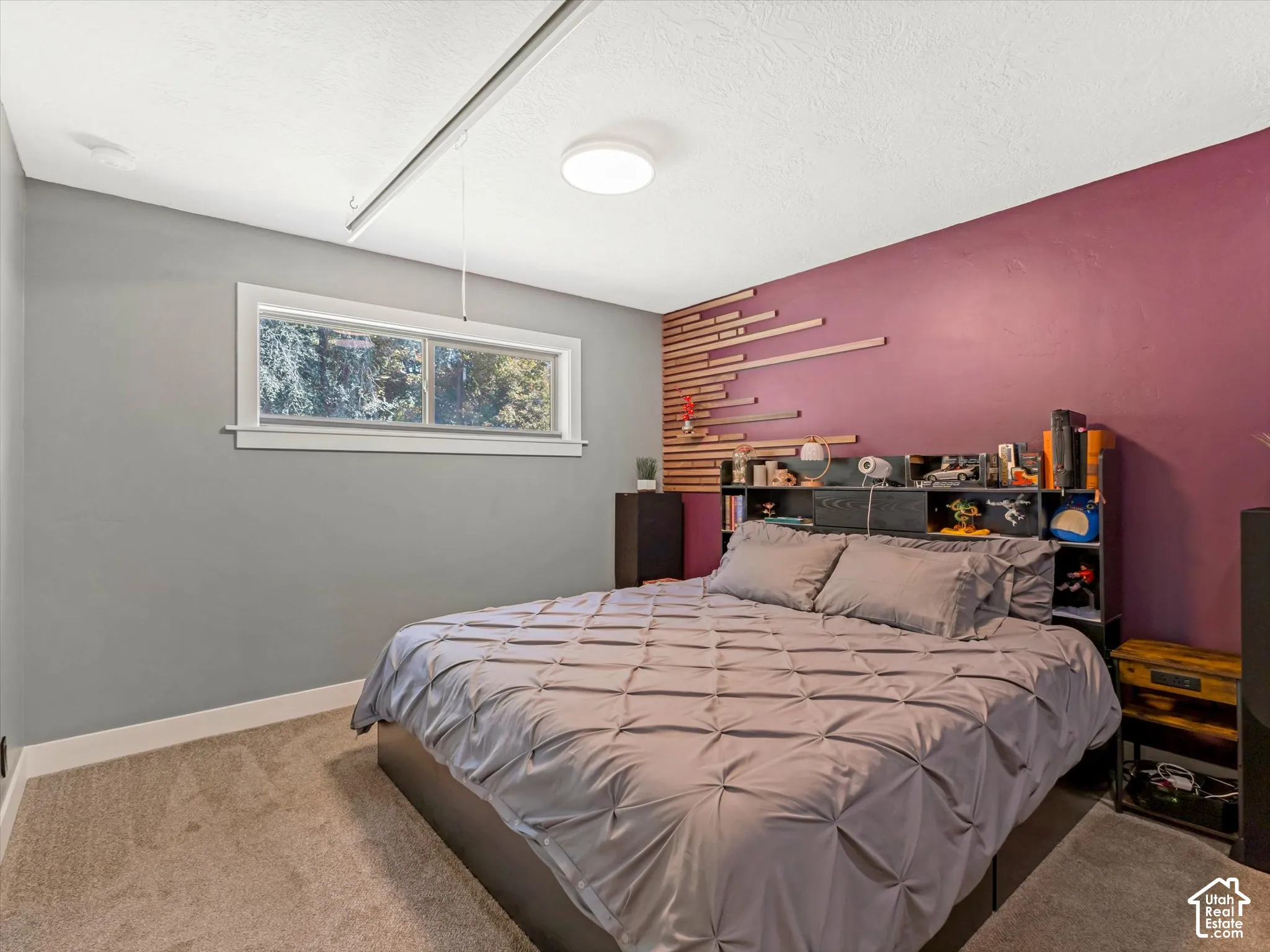 Carpeted flooring, recessed ceiling light, built-in shelving, decorative wood wall paneling, and a window with white trim