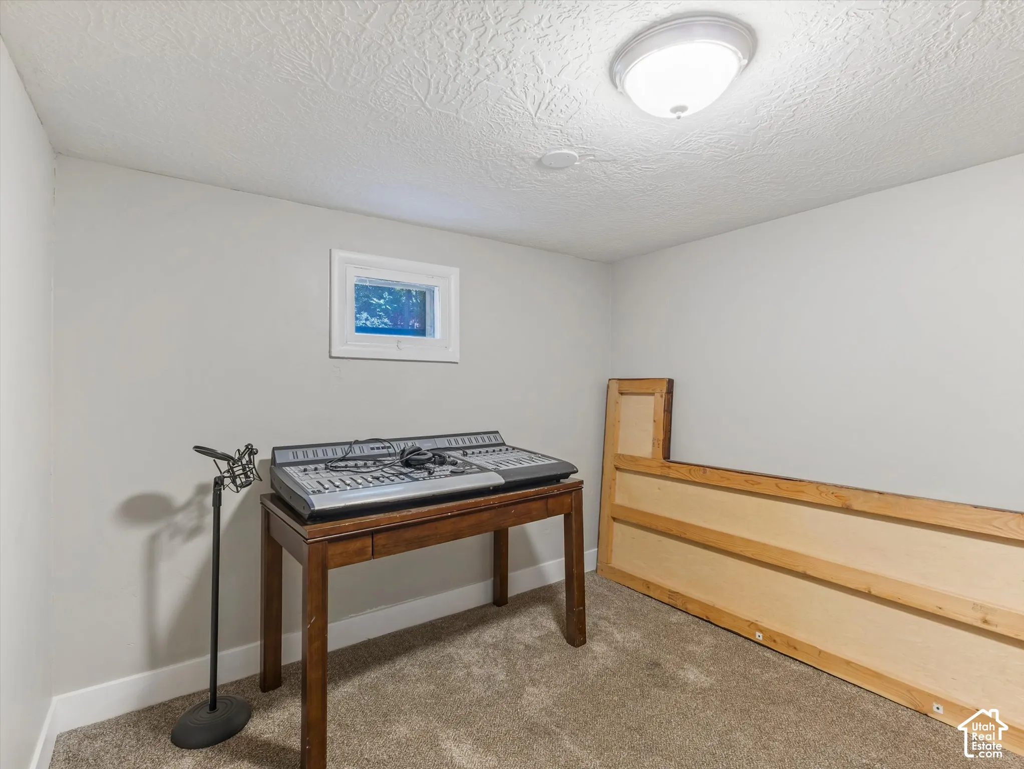 Recessed window with white trim, neutral-toned walls, textured ceiling, and flush mount lighting