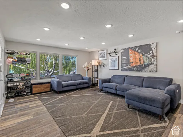 Recessed ceiling lighting, wood-finish flooring, ample natural light, and a built-in window bench