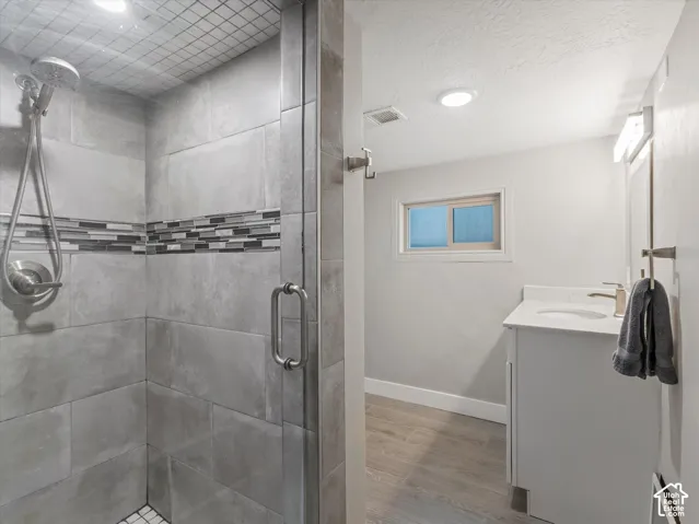 Shower with full tile surround, mosaic accent band, and glass enclosure