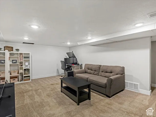 Recessed ceiling lighting, textured wall paneling, carpeting, and white baseboards