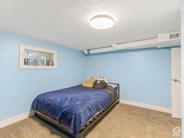Recessed window with white trim, light blue wall paint, and textured ceiling