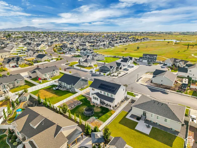 Expansive residential neighborhood with distant mountain scenery, featuring well-maintained streets, green spaces, and a golf course