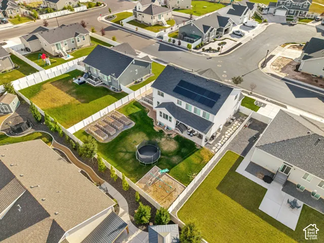 Expansive backyard featuring a manicured lawn, raised garden beds, and an established privacy fence