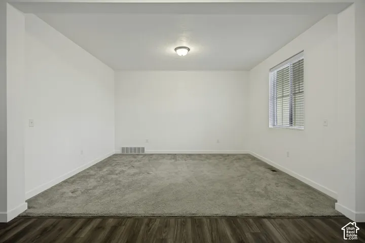 Neutral color palette, carpeted flooring, wood-finish flooring, recessed ceiling light fixture, and window with blinds