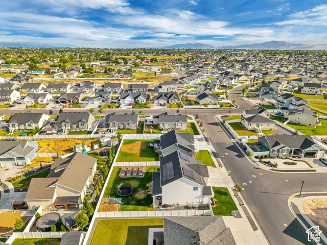 Residential property featuring a spacious backyard, paved driveway, and solar panels