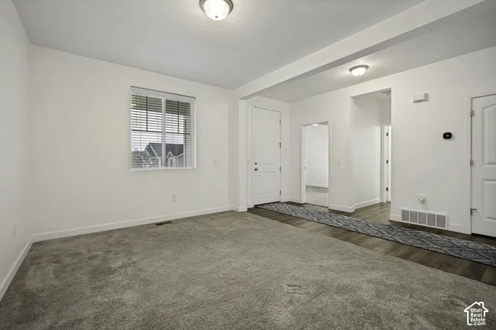 Recessed window with blinds, wood-finish flooring, two-panel interior doors, and flush-mount ceiling lights