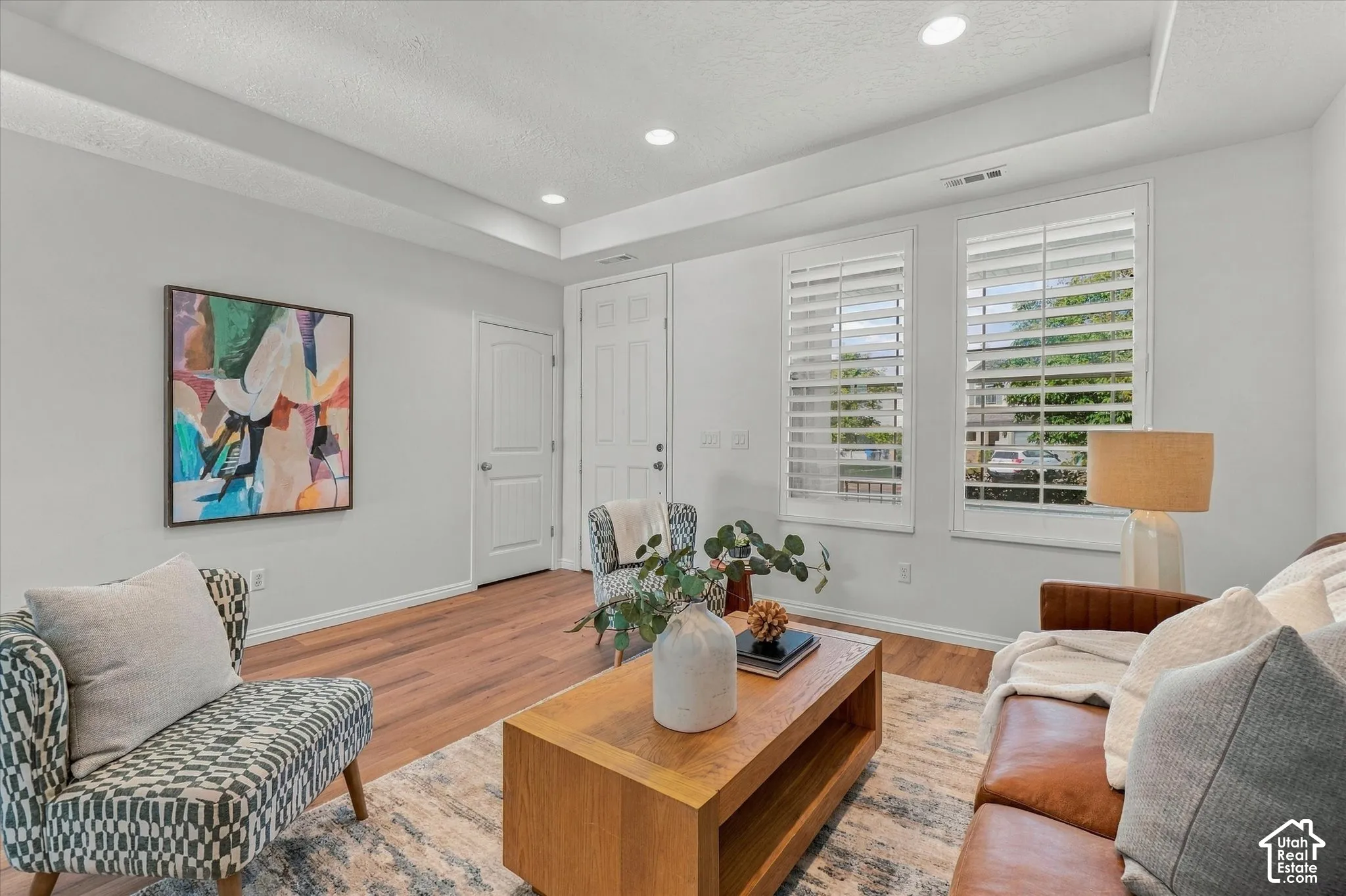 Recessed lighting, tray ceiling, two panel interior doors, and wood-finish flooring
