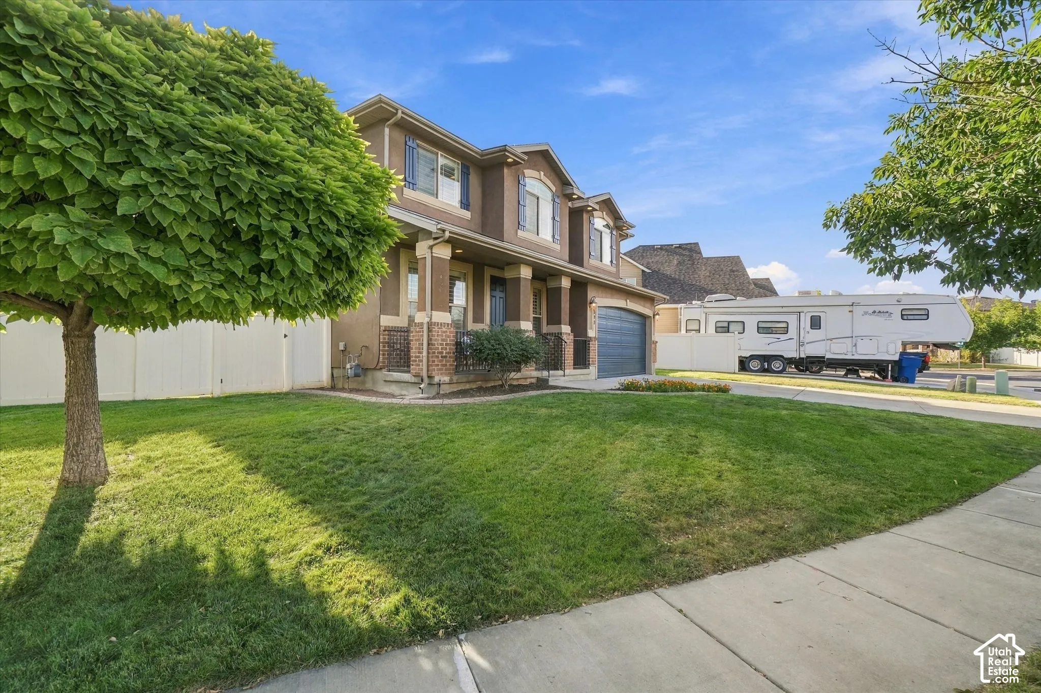Two-story residence with brick and stucco exterior, arched garage door, and covered entry