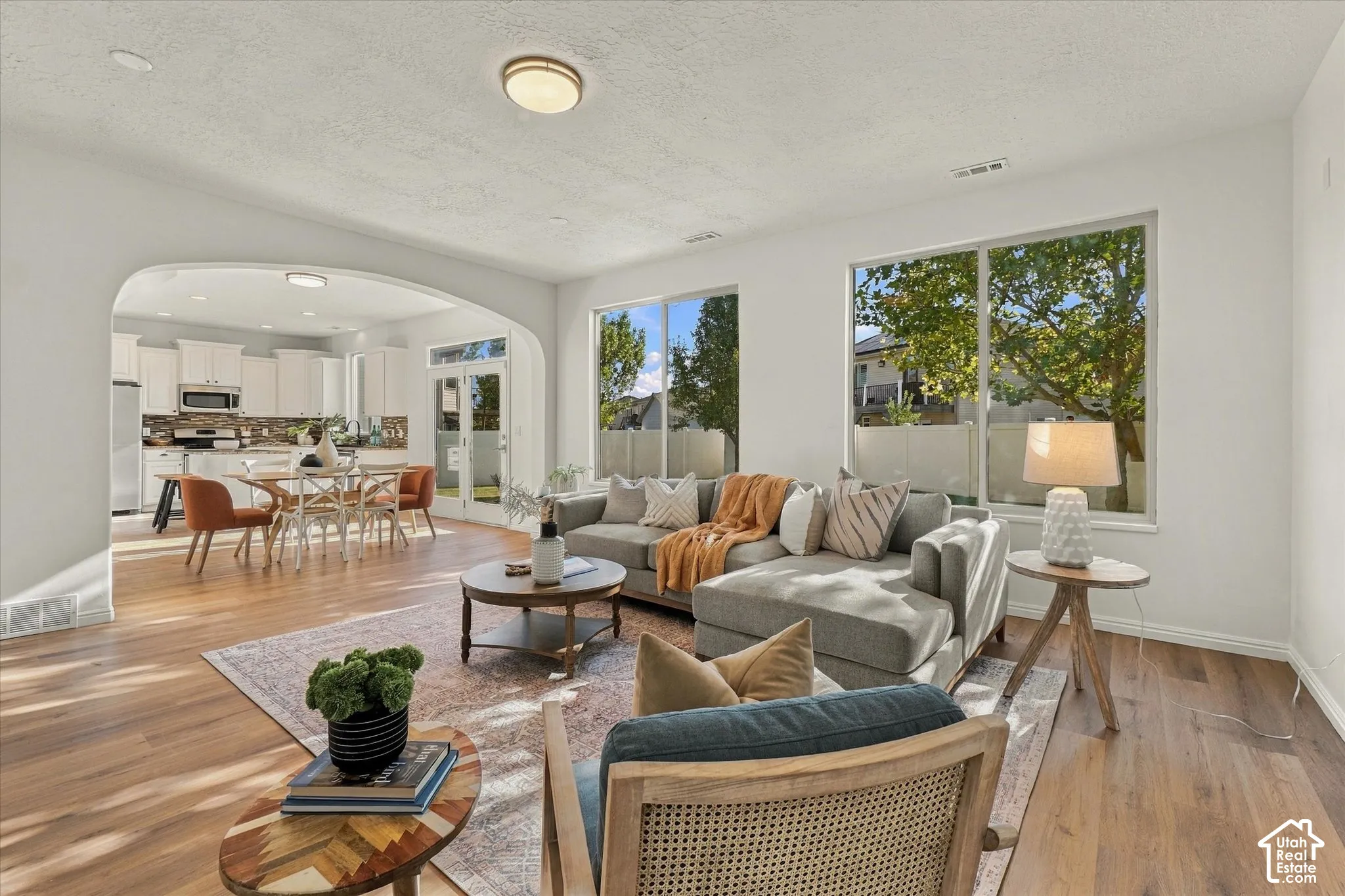 Arched entryway to the dining area, wood-finish flooring, recessed lighting, and large windows