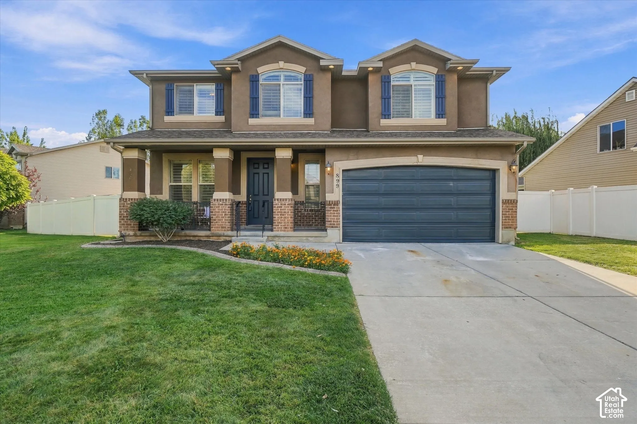 Two-story exterior with a covered porch, an attached garage, and a concrete driveway