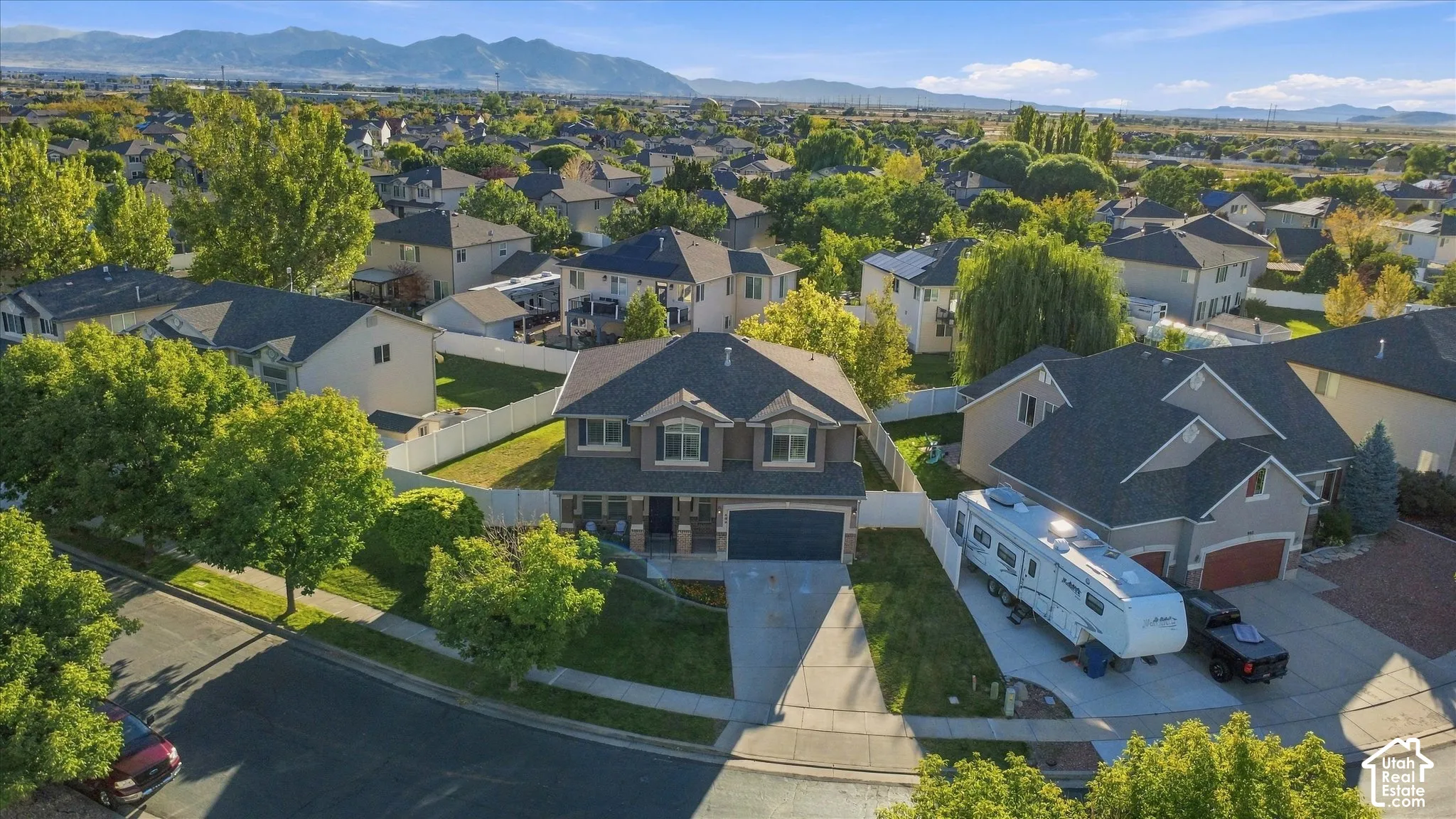 Traditional two-story residence with a multi-car driveway, attached garage, and mature landscaping