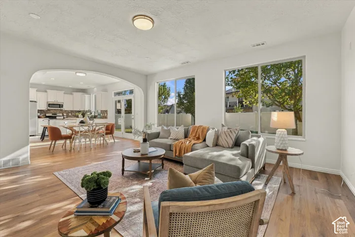 Arched entryway to the dining area, wood-finish flooring, recessed lighting, and large windows