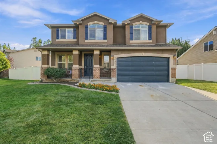 Two-story exterior with a covered porch, an attached garage, and a concrete driveway