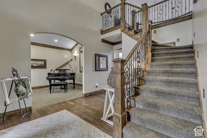Grand staircase with wood-finish newel posts and wrought iron balusters