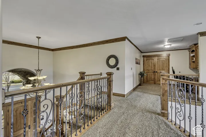 Upper-level landing featuring wood-finished trim, wrought iron and wood-finished railings, recessed lighting, and double-entry doors