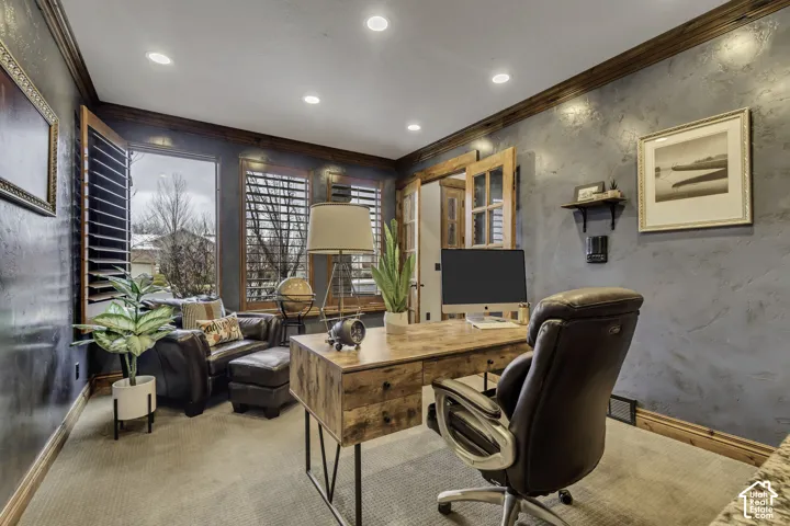 Recessed lighting illuminates the room, featuring wood-finish flooring, wood trim, and wood-framed windows with plantation shutters