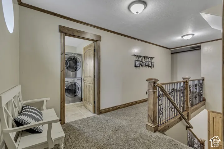 Wood-finish trim details throughout, carpeted flooring, and a laundry closet with stacked appliances