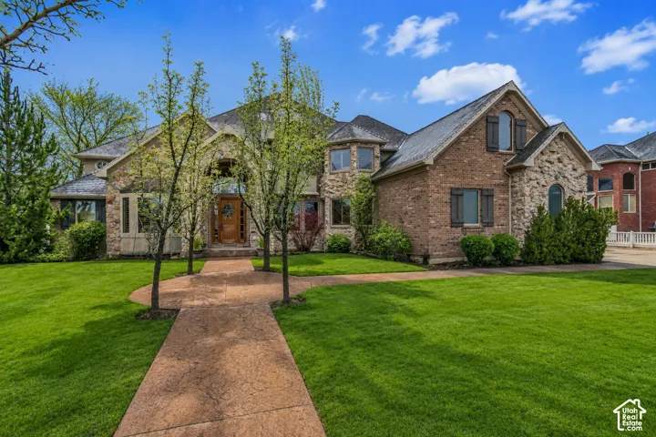 Brick and stone exterior featuring multiple gables, arched windows, and decorative shutters