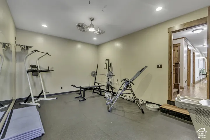Dedicated exercise room featuring a rubberized floor, recessed lighting, and a ceiling fan