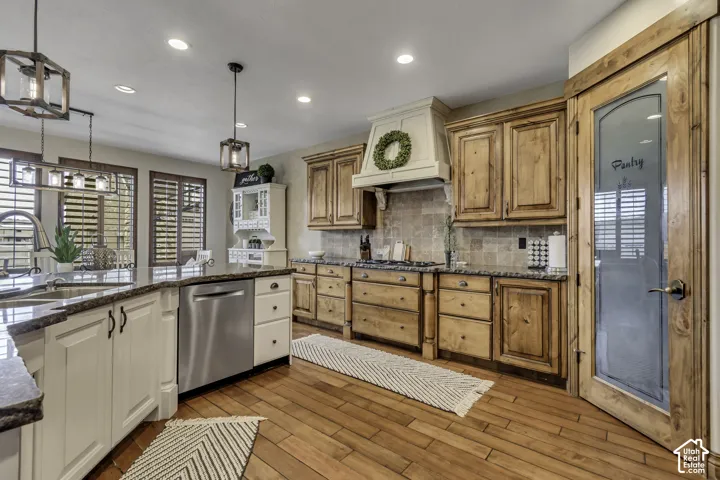 Wood-finish flooring throughout, with a kitchen island featuring a built-in sink and stainless steel dishwasher