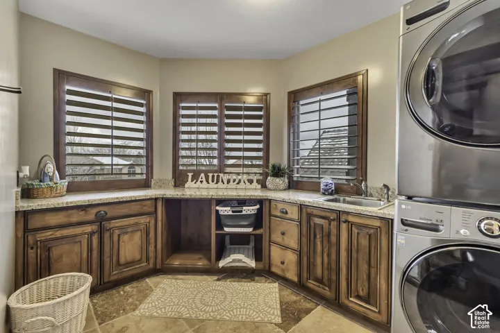 Custom cabinetry with corner sink, granite countertops, tile flooring, and two windows with plantation shutters