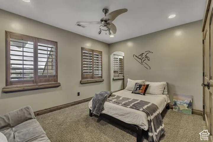 Recessed lighting, ceiling fan, wood-finish plantation shutters, wood-finish trim, and carpeted flooring