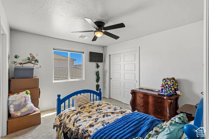 Recessed window with horizontal blinds, ceiling fan with integrated lighting, and sliding panel closet doors