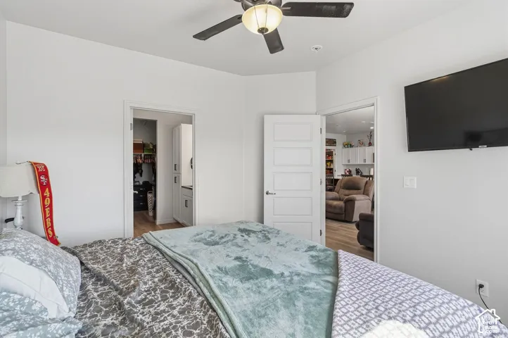 Ceiling fan with integrated lighting, wall-mounted television, and a five-panel interior door