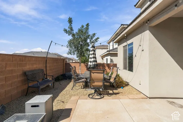 Private backyard featuring a concrete block perimeter wall, gravel landscaping, and a concrete patio