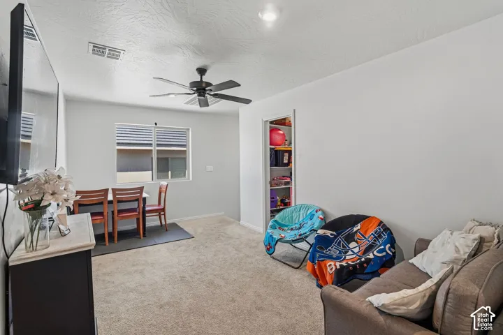 Recessed lighting, ceiling fan, built-in shelving, window with blinds, and carpeted flooring
