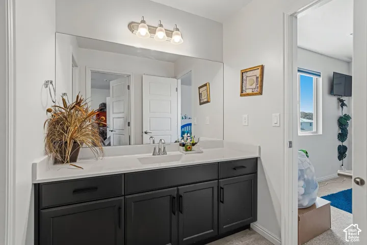 Floating vanity with a light-colored countertop, integrated rectangular sink, and dual-handle faucet