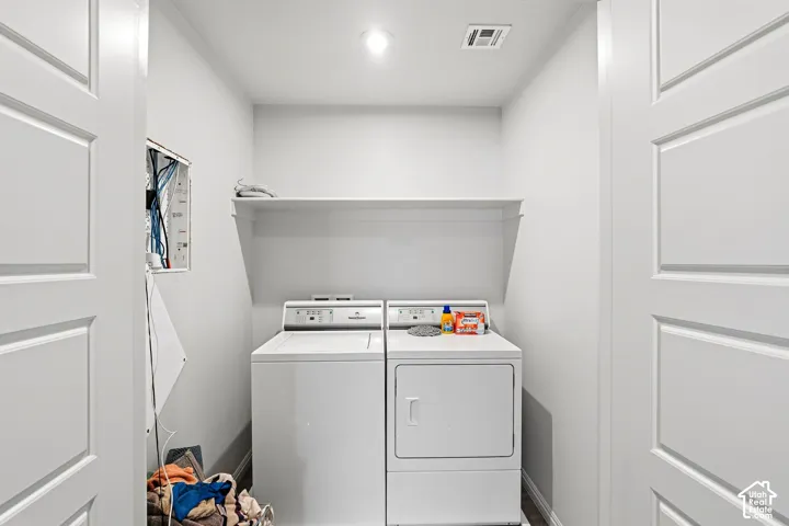 Dedicated laundry area featuring a built-in shelf, overhead lighting, and panel doors