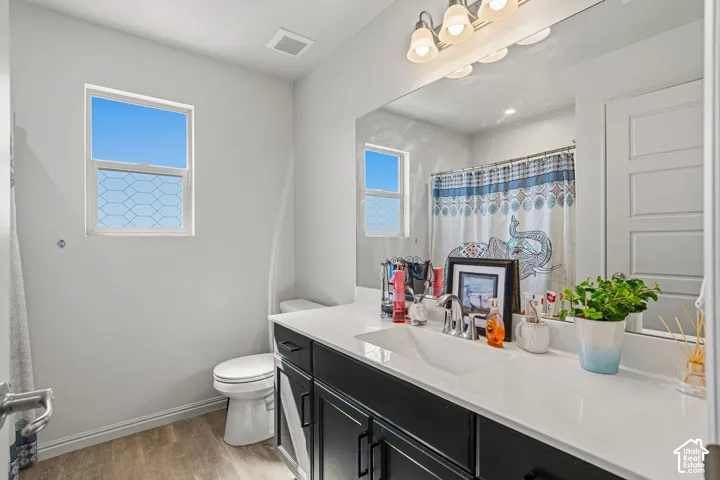 White vanity with a single basin sink, chrome faucet, and dark cabinetry